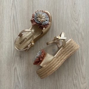 Sandalia dorada en cuero con pompón y plataforma en yute
